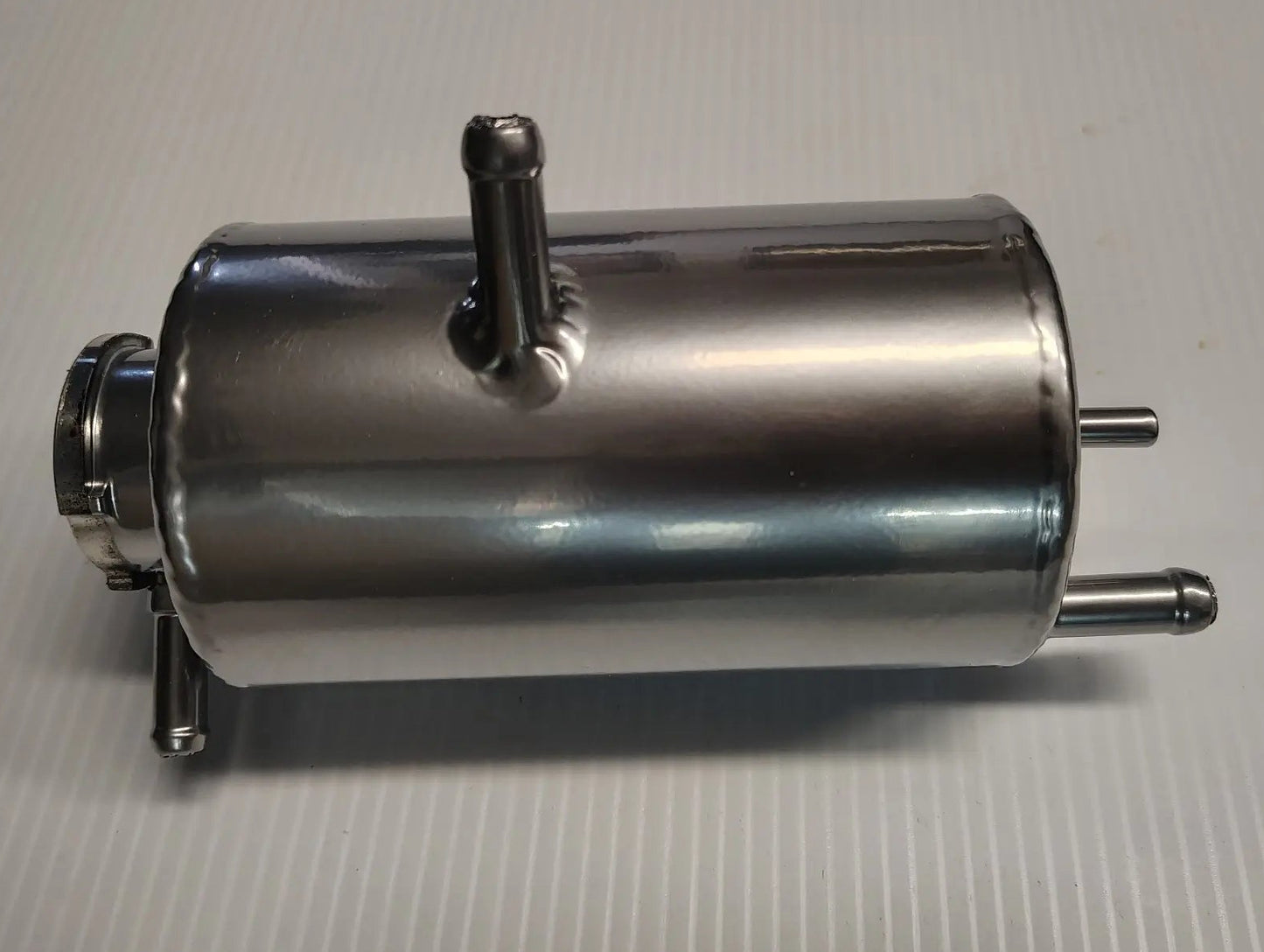 Metal cylindrical component on a gray background