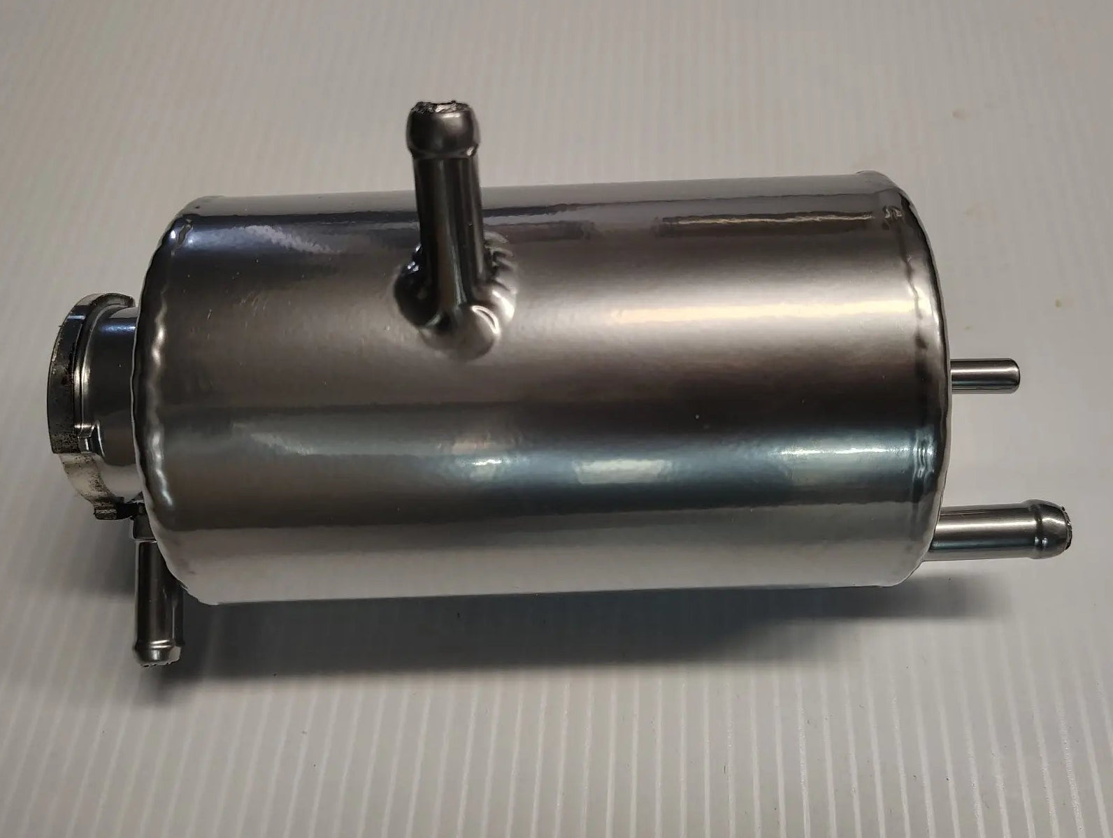 Metal cylindrical component on a gray background