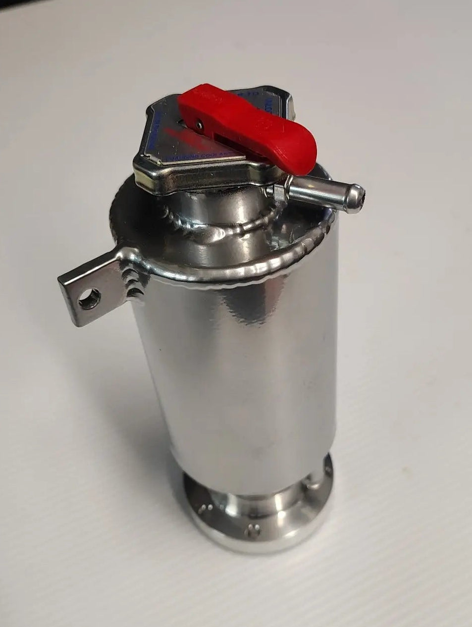 Metal container with a red valve on a white surface
